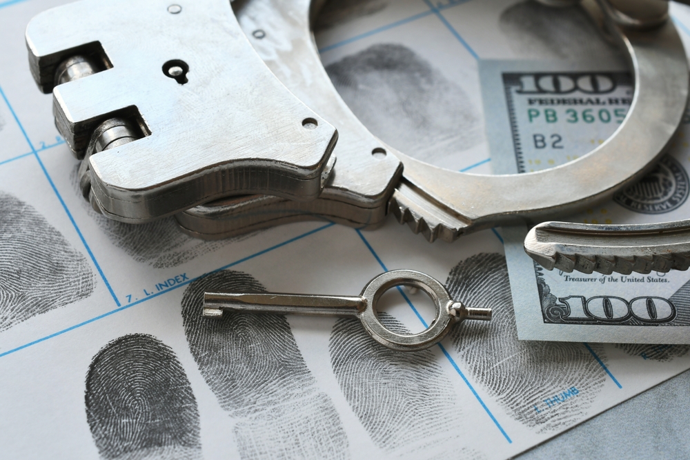 Handcuffs,laying,on,fingerprint,card,with,money, ,concept,for