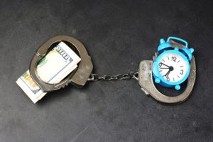 Handcuffs,,money,and,alarm,clock,on,dark,background,,bail,concept