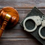 Arrest,concept.,handcuffs,near,judge,gavel,on,dark,wooden,background