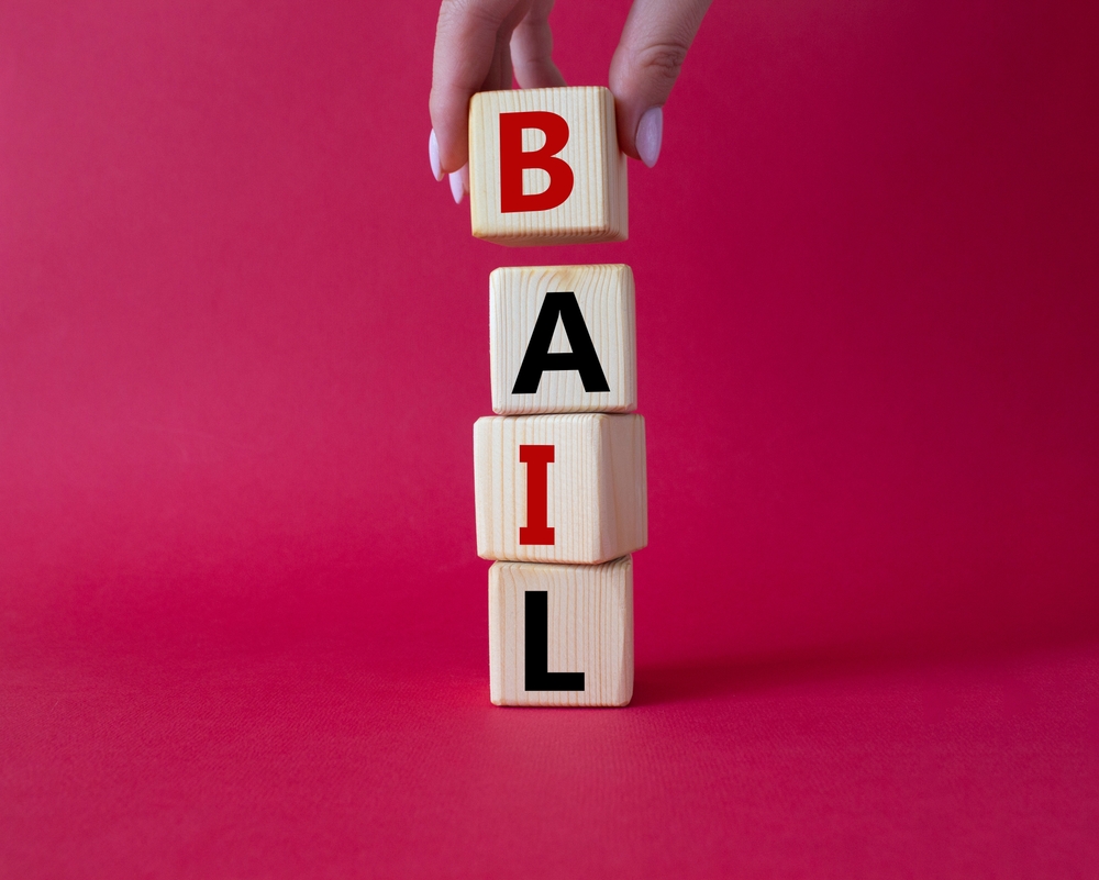 Bail,symbol.,concept,word,bail,on,wooden,cubes.,businessman,hand.